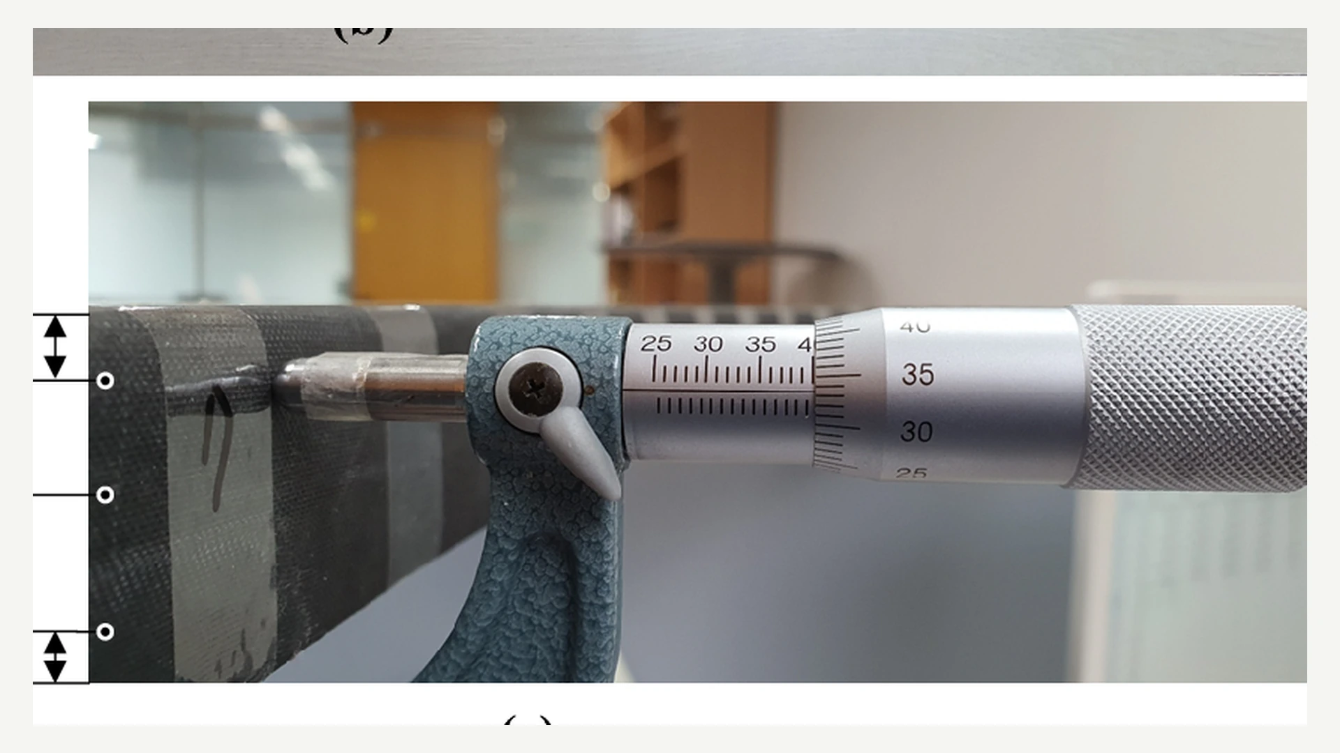 Micrometer measuring carbon-fiber laminate thickness, illustrative reference