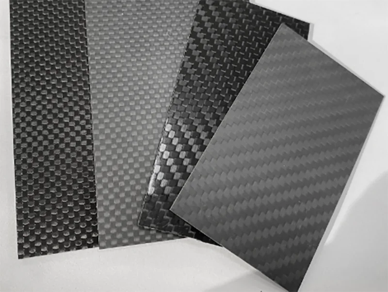 Several carbon-fiber sheet samples with differing visible surface textures