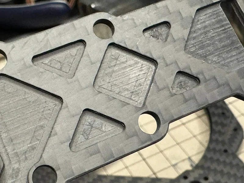 Machined carbon fiber part with precision hole features for CNC feasibility review